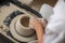 Ceramist makes a pot of clay on a potter`s wheel