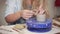 Ceramist woman is fixing handle to clay cup in workshop, close-up