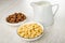 Cereal breakfasts with chocolate and caramel in bowls, pitcher with yogurt on table