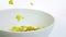 Cereal corn flakes falling down in a bowl, shot in slow motion on white background, concept of diet healthy food