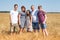Cereal farmer family with wife, two teenage sons and preteen daughter, long family portrait on yellow wheat field
