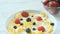 Cereal flakes with fresh berries, honey and milk for breakfast, close-up