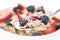 Cereals bowl with red fruits on white