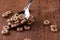 Cereals on metal spoon on brown wooden table