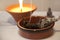 Ceremonial White Sage Smudge Stick burning with a candle flame burning in the background