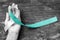 Cervical Cancer awareness with teal and white ribbon symbolic bow color on woman helping hand support on old aged wood