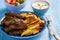 Cevapcici, balkanian grilled meat sausages with fries and yogurt dip.