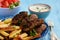 Cevapcici, balkanian grilled meat sausages with fries and yogurt dip.