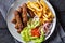 Cevapcici with potato fries, lettuce, onion, ajvar