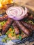 Cevapi on a plate, traditional balkan dish, grilled minced beef meat, Cevapcici, with onion and french fries served in restaraunt