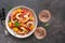 Ceviche with shrimps and orange, two glasses of pink sparkling wine, dark rustic background. Top view, copy space