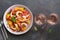 Ceviche with shrimps and orange, two glasses of pink sparkling wine, dark rustic background. Top view, copy space