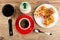 Cezve, sugar, pieces of khachapuri with tomato and basil in plate, cup with coffee on saucer, spoon on table. Top view