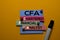 CFA. Chartered Financial Analyst acronym on sticky notes. Office desk background