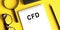 CFD acronym for Contract For Difference is on a notepad next to glasses, a pencil and a magnifying glass on a yellow background