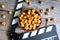 CFlat lay of tasty caramel popcorn and clapperboard on wooden table, top view. Movie time concept