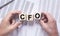 CFO acronym, chief financial officer concept. cubes in male hands on office table, top view