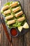 Cha gio or nem ran or fried spring roll, is a popular dish in Vietnamese cuisine closeup on the plate. Vertical top view