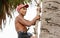 CHACHOENGSAO, THAILAND - MAY 12,2019 : Farmer middle-aged man climbing the palmyra palm tree or science name Borassus flabellifer