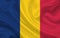 Chad country flag on wavy silk fabric background panorama