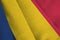 Chad flag with big folds waving close up under the studio light indoors. The official symbols and colors in banner