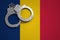 Chad flag and police handcuffs. The concept of crime and offenses in the country