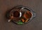 Chaga tea in a glass bowl and teapot on a brown background. Organic infusion with chaga mushrooms in a wooden tray. Top view, flat