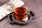 Chaga tea in transparent cup on wooden serving plate. Healthy herbal drink. Natural antioxidant. Prepared from dried birch