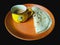 Chai Paratha - Emoji cup Tea served with Flatbread isolated black background is a traditional simple meal from India, Pakistan and