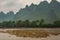 Chain of forested Karst mountains and marsh land in front along Li River in Guilin, China