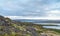 The chain of lakes in the tundra of the Kola Peninsula in inclement weather, green moss and lichens, rocks, The Barents Sea is in