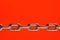 A chain of links is isolated on a red background.