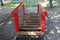 Chain suspended wooden bridge vintage retro outdoor public playground equipment surrounded with gravel and grass in local