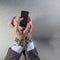 chain tied businessman typing on mobile phone for modern dependency