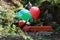 Chainsaw with chain-covered and colorful balloons in forest.