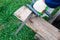 Chainsaw and log on a background of green grass. View from above