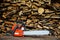 Chainsaw is on sawn firewood background