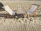 Chair, deck chair and table on the sand