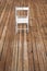 Chair and empty space on wooden floor. Single chair standing alone on wooden floor in empty room. Blank floor background. Studio