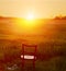 Chair in the field and glasses in the grass at sunset