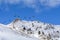 Chair ski lift with skiers over blue sky. Panorama of snow moun