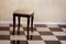 Chair-stool furniture on the tiled floor in a cage.