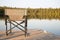 A Chair on a Wooden Dock Looking Out on a Lake in Summer