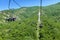 Chairlift going up the mountain. Beautiful sunset on the mountains full of trees, orange, green and blue behind the chairlift