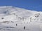 Chairlift at Italian ski area on snow covered Alps and skiers and snowboarders on the piste - winter sports concept