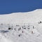 Chairlift at Italian ski area on snow covered Alps and skiers and snowboarders on the piste - winter sports concept