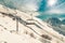 Chairlift lifts skiers and snowboarders to the top of the mountain near the village of Dombai, Russia in a winter sunny day