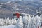 Chairlift with one person wearing red ski suit at Stowe Ski Resort in Vermont, view to the Mansfield mountain slopes