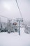 Chairlift with skiers ascends a snowy slope in the Kolasin 1600 resort. Montenegro