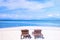 Chairs on the amazing beautiful sandy beach near the ocean with blue sky. Concept of summer leisure calm vacation for a tourism